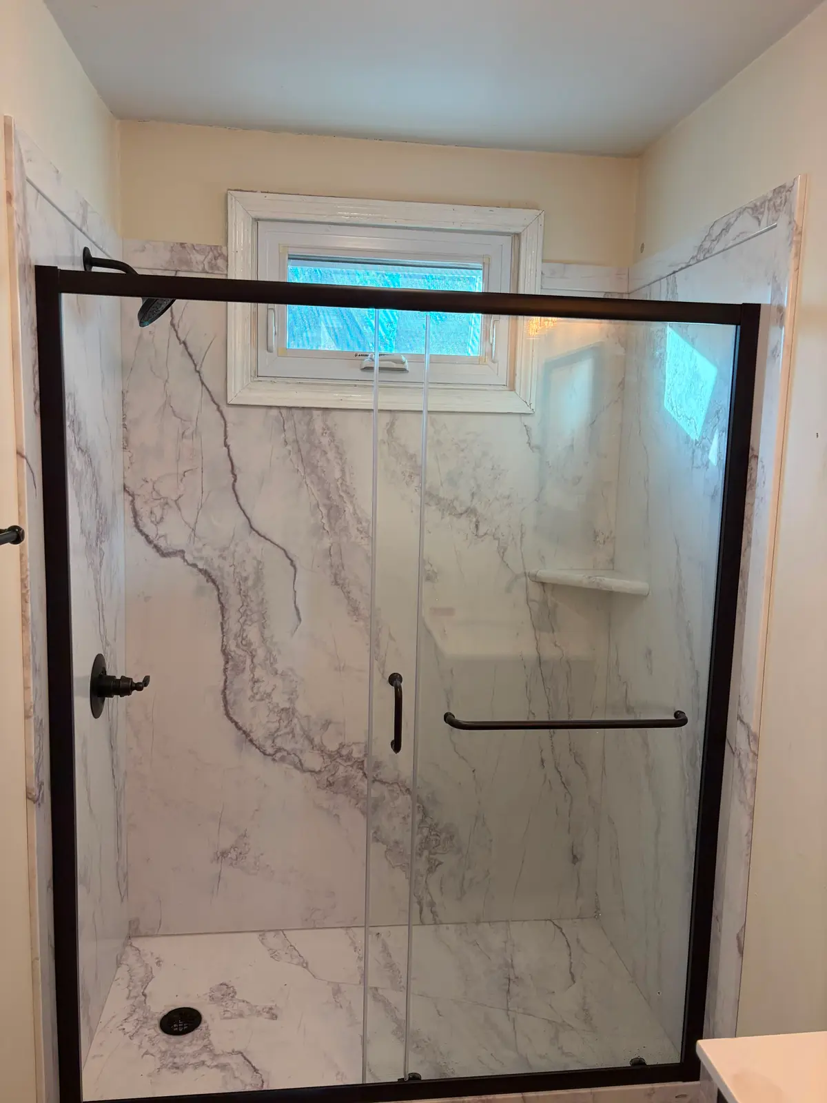 Finished marble-look walk-in shower with a glass door after a C&C Multiservices bathroom remodel in Connecticut