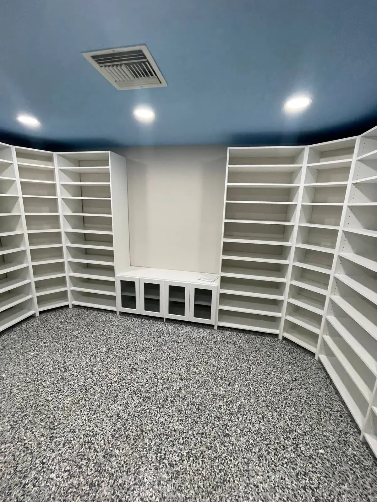 Floor-to-ceiling white shelving wrapping a home library, custom-built by C&C Multiservices in Connecticut