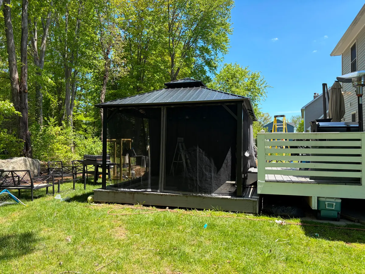 Completed hardtop gazebo with mosquito netting installed on a backyard deck by C&C Multiservices in Connecticut